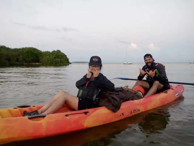 Two-person tandem kayak on glowing bioluminescent water