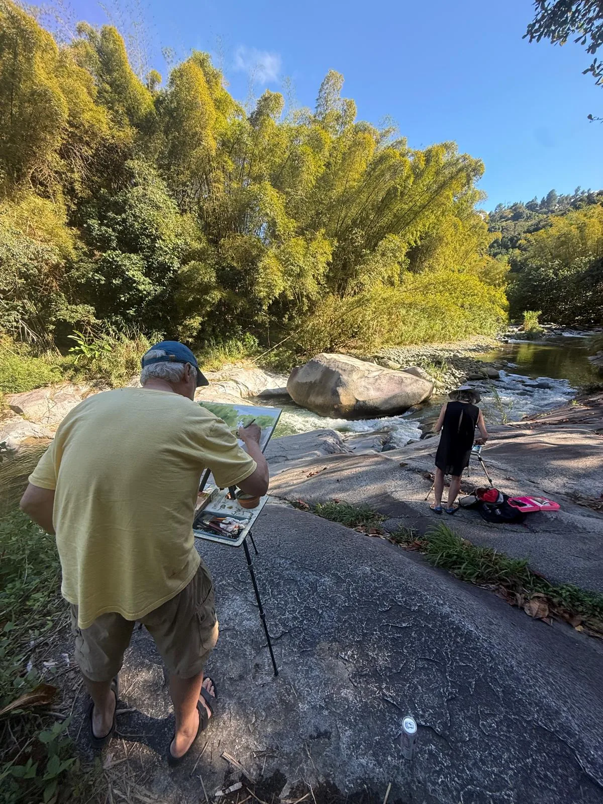 Artists painting plein air beside a mountain river in Jayuya