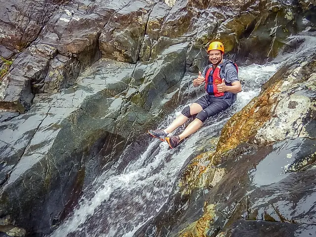 Guest sliding down natural rock waterslide in El Yunque