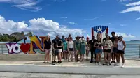 Group at the Yo Amo Naguabo sign on the Malecón boardwalk